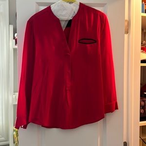 Silk blouse with black trim pocket.